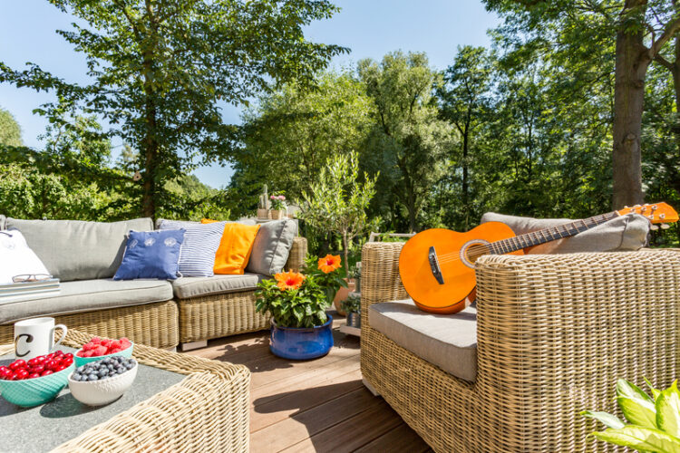 New patio furniture with throw pillows as pops of color on a deck.